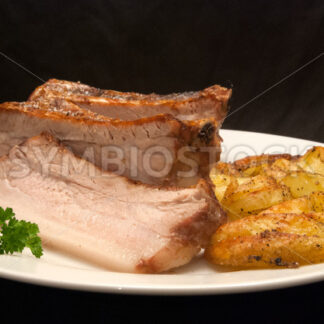 Gegrillter Schweinebauch mit frittierten Kartoffelspalten Frontal - Fotos-Schmiede